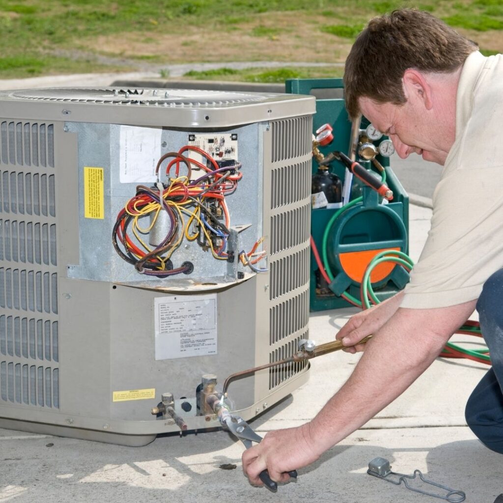 a man repairing an AC unit