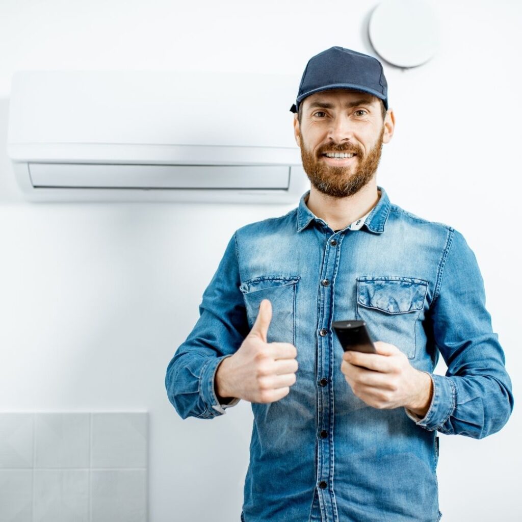 Technician with installed air conditioner
